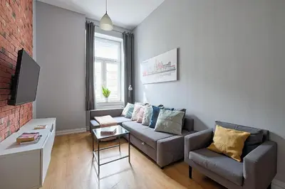 a living room with a couch and a chair at Urban Nest Apartments Krakowska 10 in Kraków