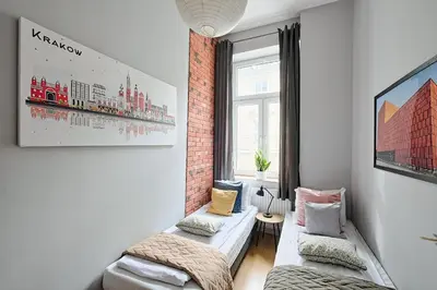 a living room with two beds and a brick wall at Urban Nest Apartments Krakowska 10 in Kraków