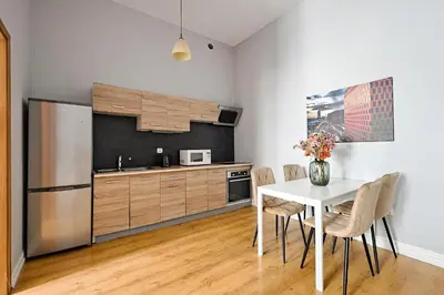 a kitchen with a white table and a refrigerator at Urban Nest Apartments Krakowska 10 in Kraków