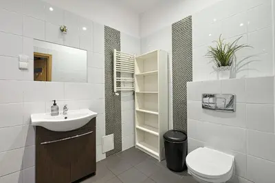 a white bathroom with a sink and a toilet at Urban Nest Apartments Krakowska 10 in Kraków