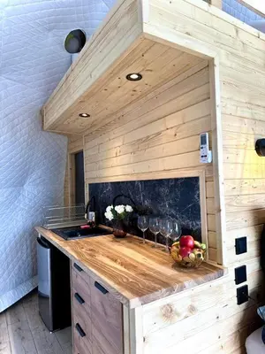 a kitchen with a wooden counter in a tiny house at Glamp Delux Ojcowski Park Narodowy in Wola Kalinowska