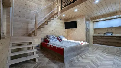 a room with a red couch in a room with stairs at Domek wypoczynkowy Górskie Zacisze in Sidzina