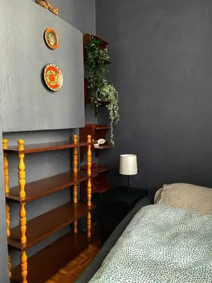 a bedroom with a bed and a clock on the wall at Small room for short stay in Kraków
