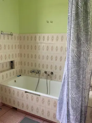 a bath tub in a bathroom with a shower curtain at Small room for short stay in Kraków