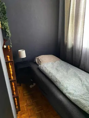 a small bedroom with a bed and a window at Small room for short stay in Kraków