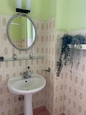 a bathroom with a sink and a mirror at Small room for short stay in Kraków