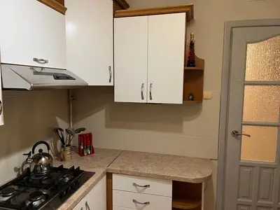 a kitchen with white cabinets and a stove top oven at Mieszkaj U Marty in Jaworzno
