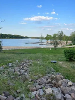 a grassy field with a lake in the background at Mieszkaj U Marty in Jaworzno