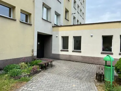 a courtyard of a building with a bench and a green object at Mieszkaj U Marty in Jaworzno