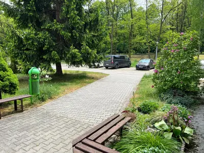 a park with a bench and a parking lot with cars at Mieszkaj U Marty in Jaworzno