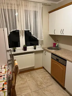 a small kitchen with a sink and a window at Mieszkaj U Marty in Jaworzno