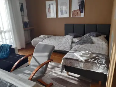 a bedroom with two beds and a chair in it at Max Apartament okolice Energylandia Zator in Oświęcim