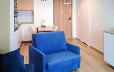 a blue chair in a living room with a table at 1 Bedroom Amazing Apartment In Zator in Zator