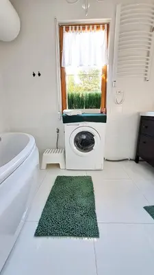 a bathroom with a washing machine in a window at Dom na Wielkiej Polanie in Sidzina