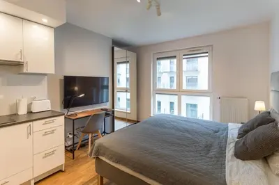 a bedroom with a bed and a desk with a computer at Zabłocie Harmony Studio B in Kraków