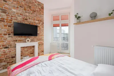 a bedroom with a brick wall and a tv at Malila Premium Apartments Cracow Centre Starowiślna 41 in Kraków