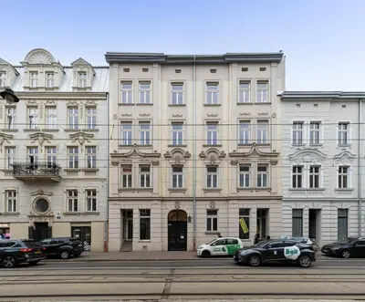 a large building with cars parked in front of it at Malila Premium Apartments Cracow Centre Starowiślna 41 in Kraków