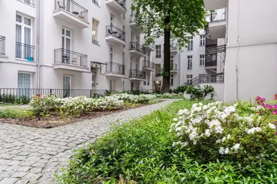 a walkway in front of a building with flowers at Malila Premium Apartments Cracow Centre Starowiślna 41 in Kraków