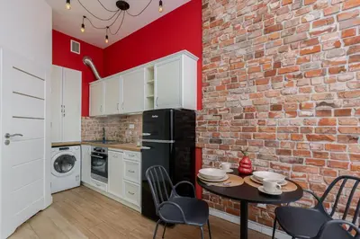 a kitchen with a brick wall and a table with chairs at Malila Premium Apartments Cracow Centre Starowiślna 41 in Kraków