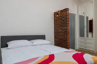 a bedroom with a bed and a brick wall at Malila Premium Apartments Cracow Centre Starowiślna 41 in Kraków