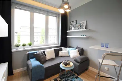 a living room with a couch and two windows at Aleja Słowackiego 18 by Homeprime in Kraków