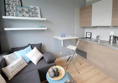 a living room with a couch and a kitchen at Aleja Słowackiego 18 by Homeprime in Kraków