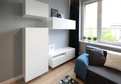 a living room with a white cabinet and a couch at Aleja Słowackiego 18 by Homeprime in Kraków