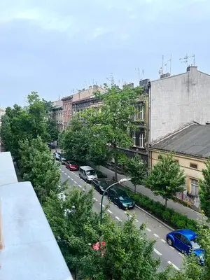 a view of a city street with cars parked at Cheerful Corner in Kraków