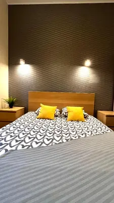 a bedroom with a bed with two yellow pillows at Double Studio City Center in Kraków