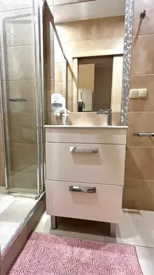 a bathroom with a sink and a shower with a mirror at Double Studio City Center in Kraków