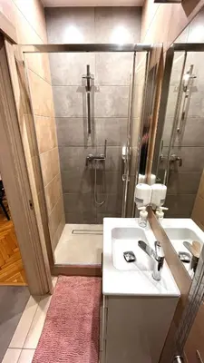 a bathroom with a shower and a sink and a sink at Double Studio City Center in Kraków