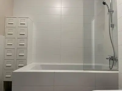 a white bathroom with a tub and a shower at Elegant Riverside Flat Garden in Kraków