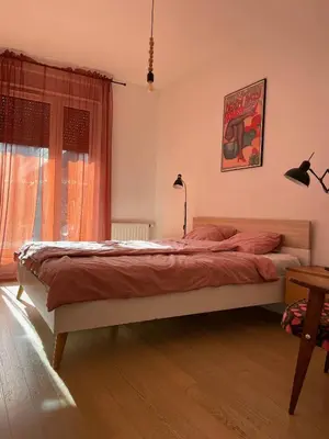 a bedroom with a bed with red sheets and a window at Elegant Riverside Flat Garden in Kraków