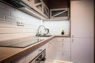 a kitchen with white cabinets and a sink at Old Railway Station view Lubicz Residence WAWELOFTS in Kraków