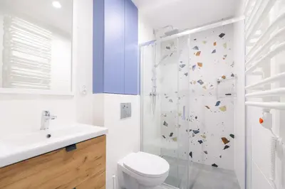 a white bathroom with a toilet and a shower at Telimeny 31 in Kraków