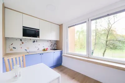 a living room with a blue couch and two windows at Telimeny 31 in Kraków