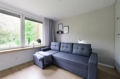 a living room with a blue couch and a window at Telimeny 31 in Kraków