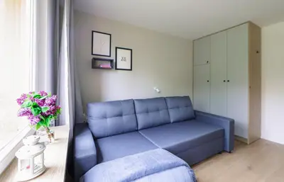 a blue couch in a room with a window at Telimeny 31 in Kraków
