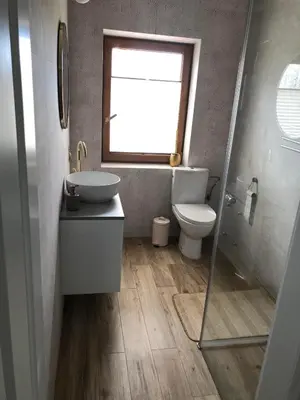 a bathroom with a toilet and a sink and a window at Noclegi DobraNocka in Sąspów