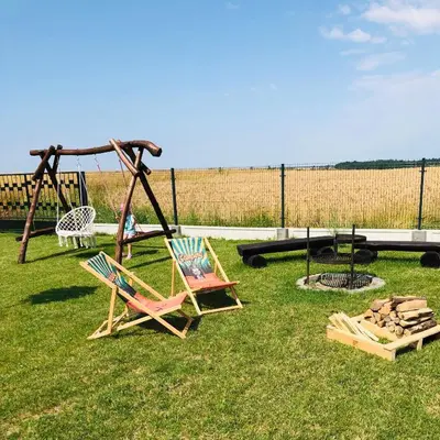 a playground with two chairs and a swing at Noclegi DobraNocka in Sąspów