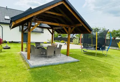 a pavilion with chairs and a table in a yard at Noclegi DobraNocka in Sąspów