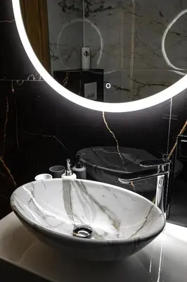 a bathroom with a white sink and a mirror at Apart Dwudziestolecie in Wadowice