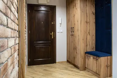 a hallway with a wooden door and a blue bench at Apart Dwudziestolecie in Wadowice