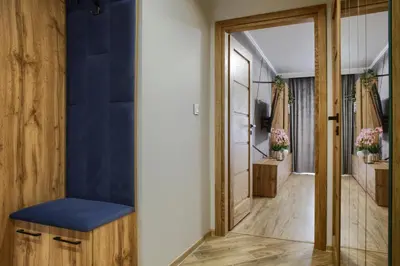 a hallway with a blue accent wall and a blue bench at Apart Dwudziestolecie in Wadowice