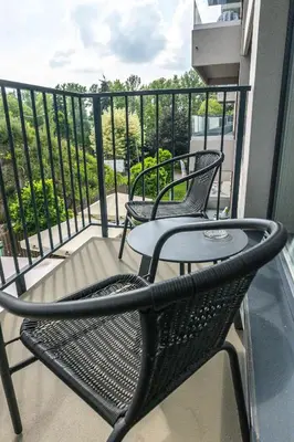 two chairs and a table on a balcony at Nowy apartament - Bulwary nad Sołą - 52m2 in Oświęcim