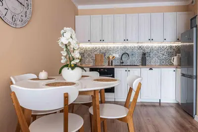 a kitchen with a table with chairs and a vase with flowers at Nowy apartament - Bulwary nad Sołą - 52m2 in Oświęcim