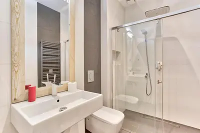 a bathroom with a sink and a toilet and a shower at Zacisze Street in Kraków