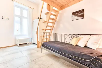 a bedroom with a bed and a spiral staircase at Zacisze Street in Kraków
