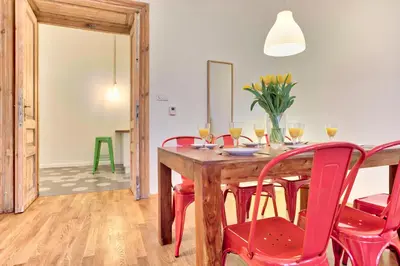 a dining room with a wooden table and red chairs at Zacisze Street in Kraków
