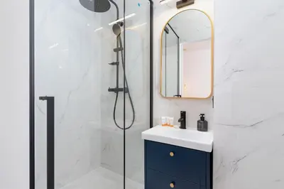 a bathroom with a shower and a sink and a mirror at Old Town Długa 48 Family Apartment by Noclegi Renters in Kraków